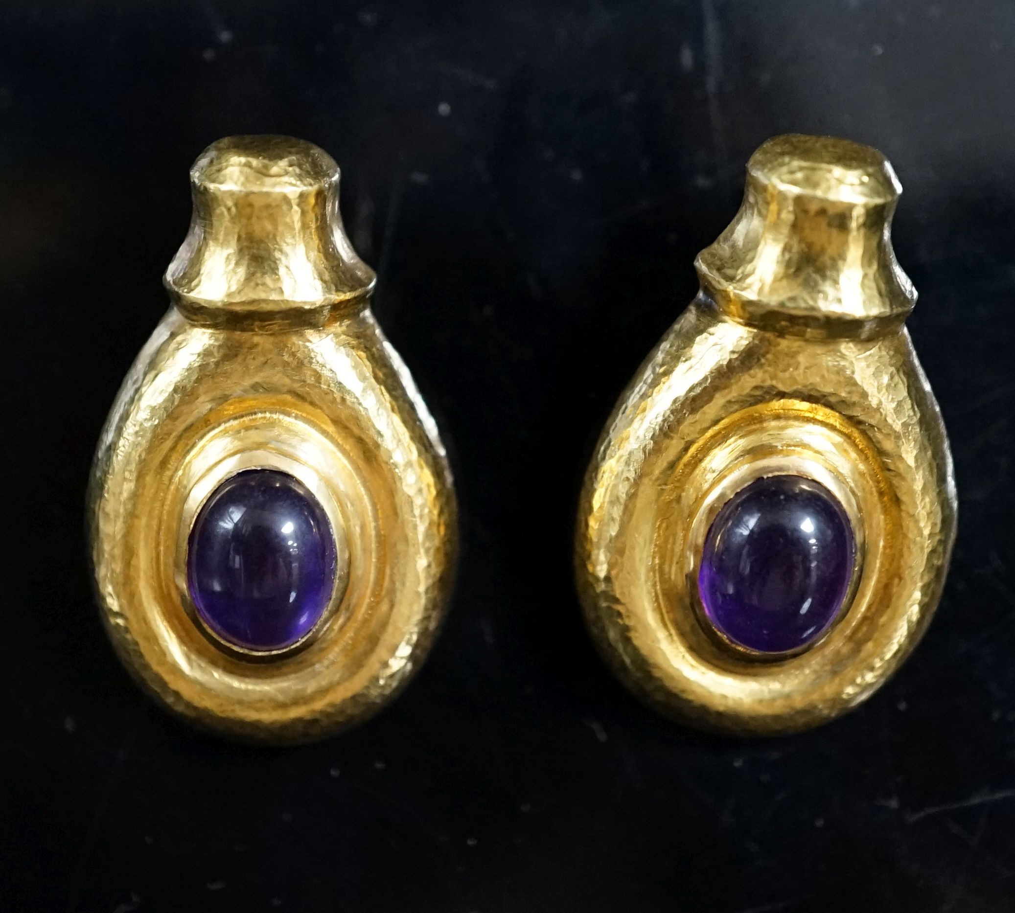 Attributed to Ilias Lalaounis, a pair of planished 750 yellow metal and cabochon amethyst set earrings, 30mm, 15.1 grams gross.